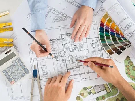 Các kiến trúc sư đang thảo luận và làm việc trên bản vẽ thiết kế.