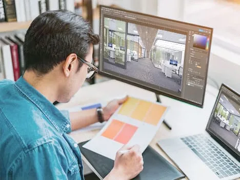 Kiến trúc sư đang thiết kế nội thất trên máy tính và bản vẽ.