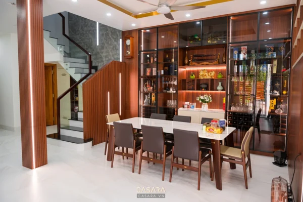 Phòng ăn hiện đại với bàn ăn gỗ, tủ rượu và lối đi quanh bàn rõ ràng