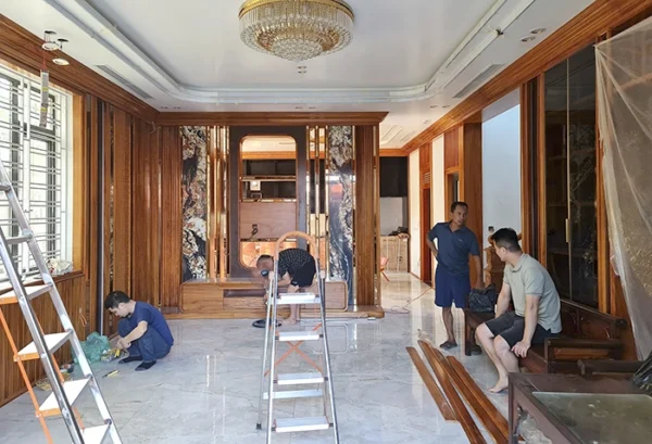 Nội thất gỗ sang trọng đang trong quá trình hoàn thiện, có công nhân làm việc.