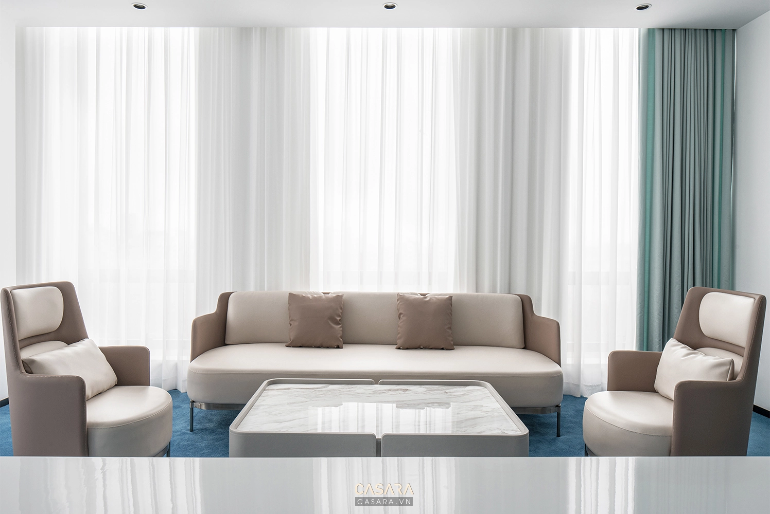 Phòng khách hiện đại với sofa vải màu trung tính, bàn trà thấp, kệ tivi gỗ, thảm lớn và cửa kính lấy sáng