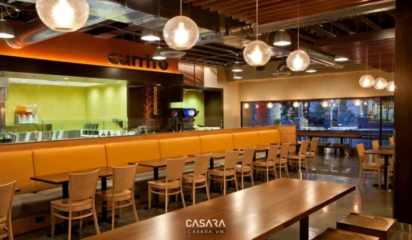 Không gian nhà hàng Currito hiện đại với tông màu cam và xanh lá.