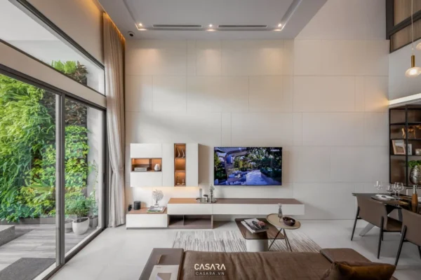 Phòng khách hiện đại, sang trọng với TV lớn và cửa kính rộng.