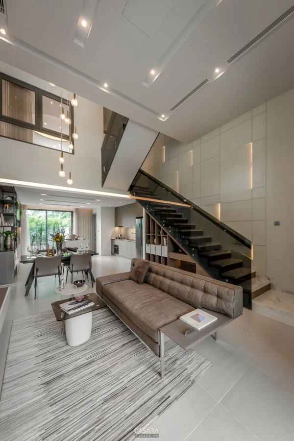 Phòng khách hiện đại, sang trọng với cầu thang kính ấn tượng.