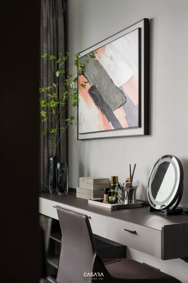 Nội thất phòng ngủ tối giản, hiện đại với tranh trừu tượng và bàn trang điểm.