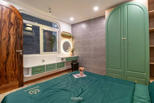 Phòng ngủ hiện đại với tủ và cửa gỗ màu xanh, tông màu tươi mát.