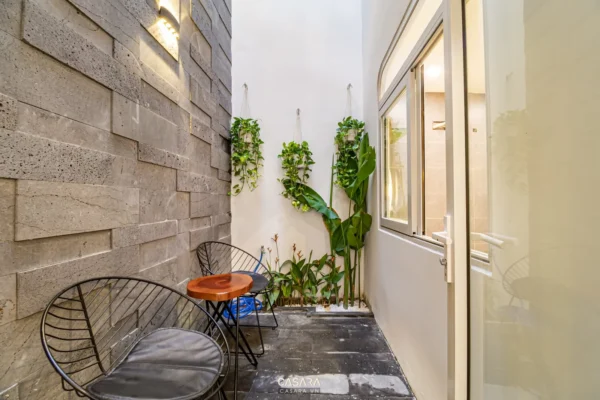 Góc sân nhỏ xinh với tường đá và cây xanh mát.