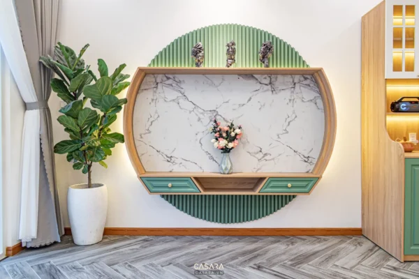 Góc trang trí tường độc đáo với kệ hình bán nguyệt và cây xanh.