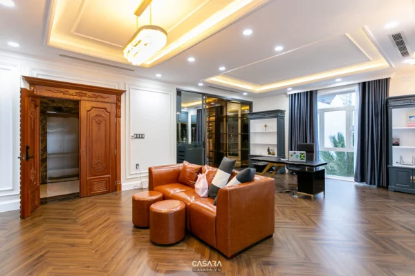 Phòng khách rộng rãi, sang trọng với nội thất gỗ và sofa da màu cam.