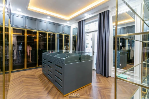 Phòng thay đồ hiện đại, sang trọng với tủ kính và ánh sáng vàng.