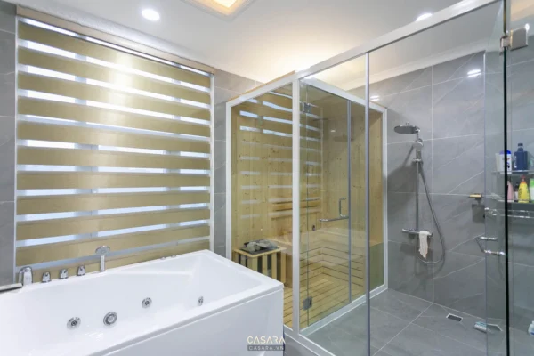 Phòng tắm hiện đại với bồn tắm và phòng xông hơi bằng gỗ sang trọng.