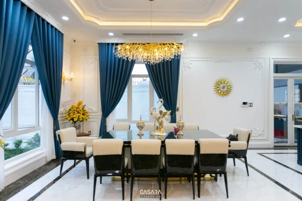 Phòng ăn sang trọng với đèn chùm pha lê và rèm nhung xanh đậm.