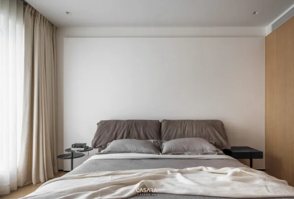 Phòng ngủ tối giản, ấm cúng với giường lớn và rèm cửa màu be.