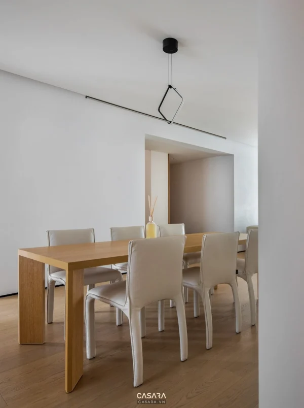 Phòng ăn tối giản với bàn gỗ sáng và ghế trắng hiện đại.