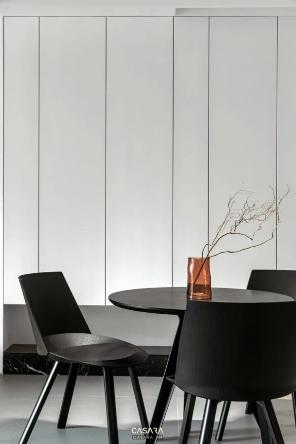 Góc phòng ăn tối giản với bàn tròn và ghế đen sang trọng.