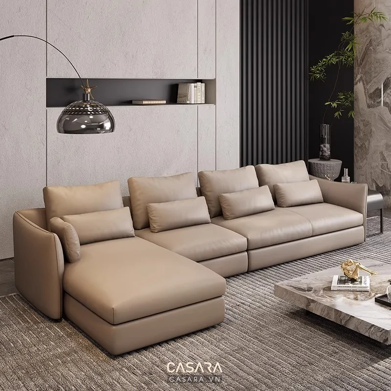 Bàn trà phòng khách bằng đá vân trắng xám với chân kim loại đen mờ, sofa xám nhạt, khay trà và sách decor