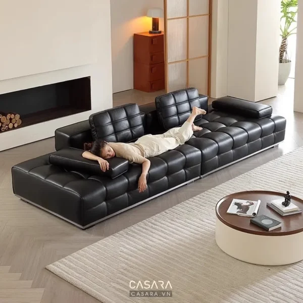 Ghế sofa đen dài, người đàn ông thư giãn trong phòng khách hiện đại.