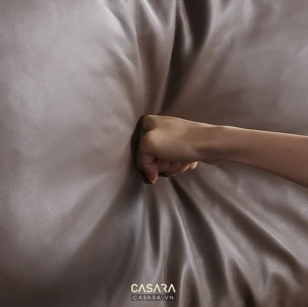 Bàn tay nắm chặt vải da mềm mại, thể hiện chất liệu cao cấp.