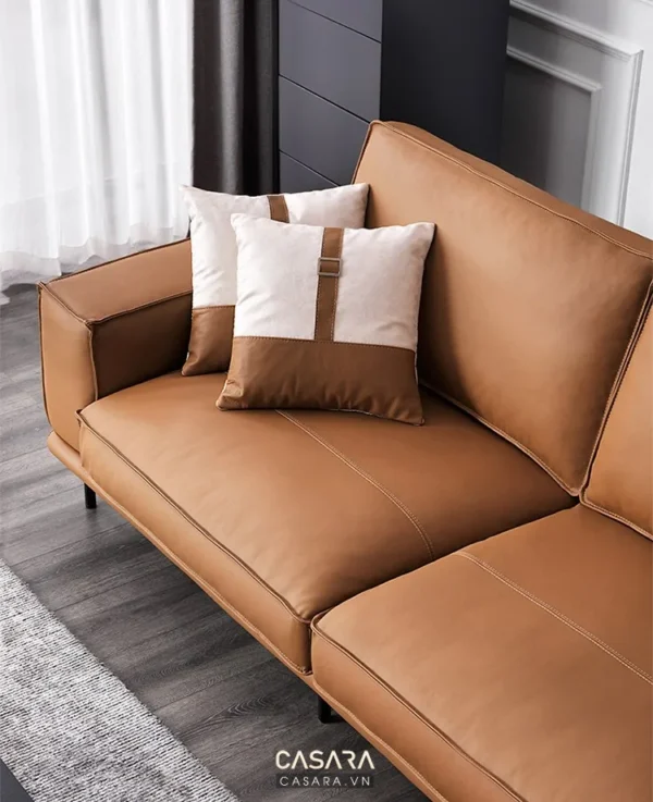 Ghế sofa da màu nâu ấm cúng với hai chiếc gối tựa trang trí.