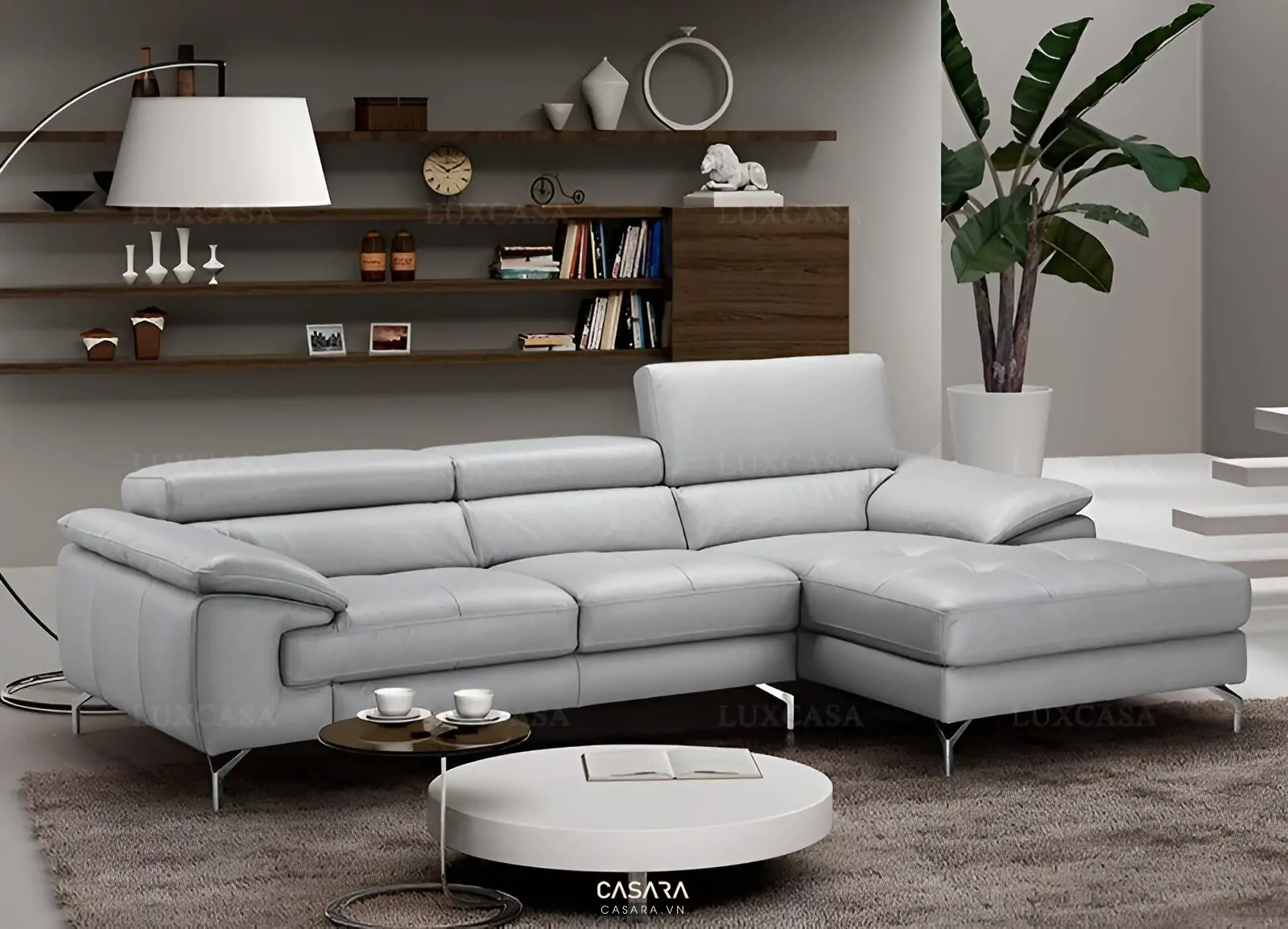 Phòng khách căn hộ với chọn màu sơn phòng khách xanh xám nhạt, sofa sáng màu, cây xanh, bàn trà tròn, thảm trung tính và phong cách hiện đại