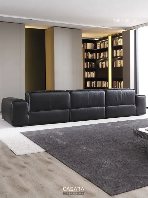 Phòng khách hiện đại với ghế sofa da đen sang trọng và kệ sách lớn.