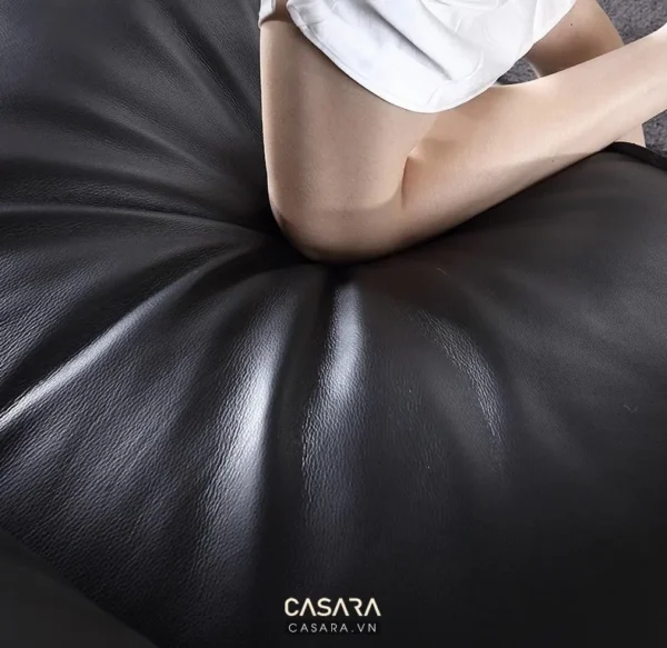 Hình ảnh cận cảnh một phần cơ thể người trên ghế da đen.