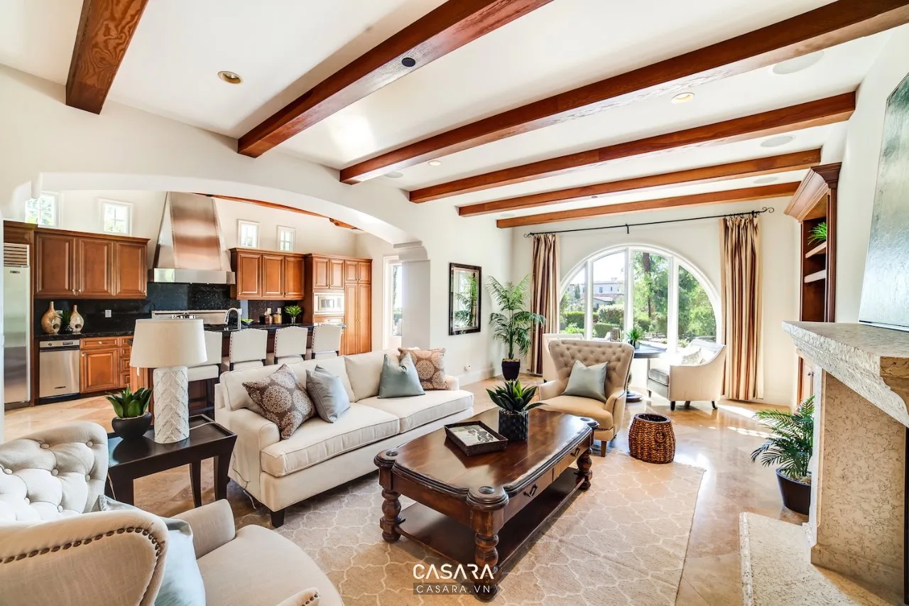 Không gian biệt thự Địa Trung Hải với trần dầm gỗ, cửa vòm, sofa sáng và cây xanh