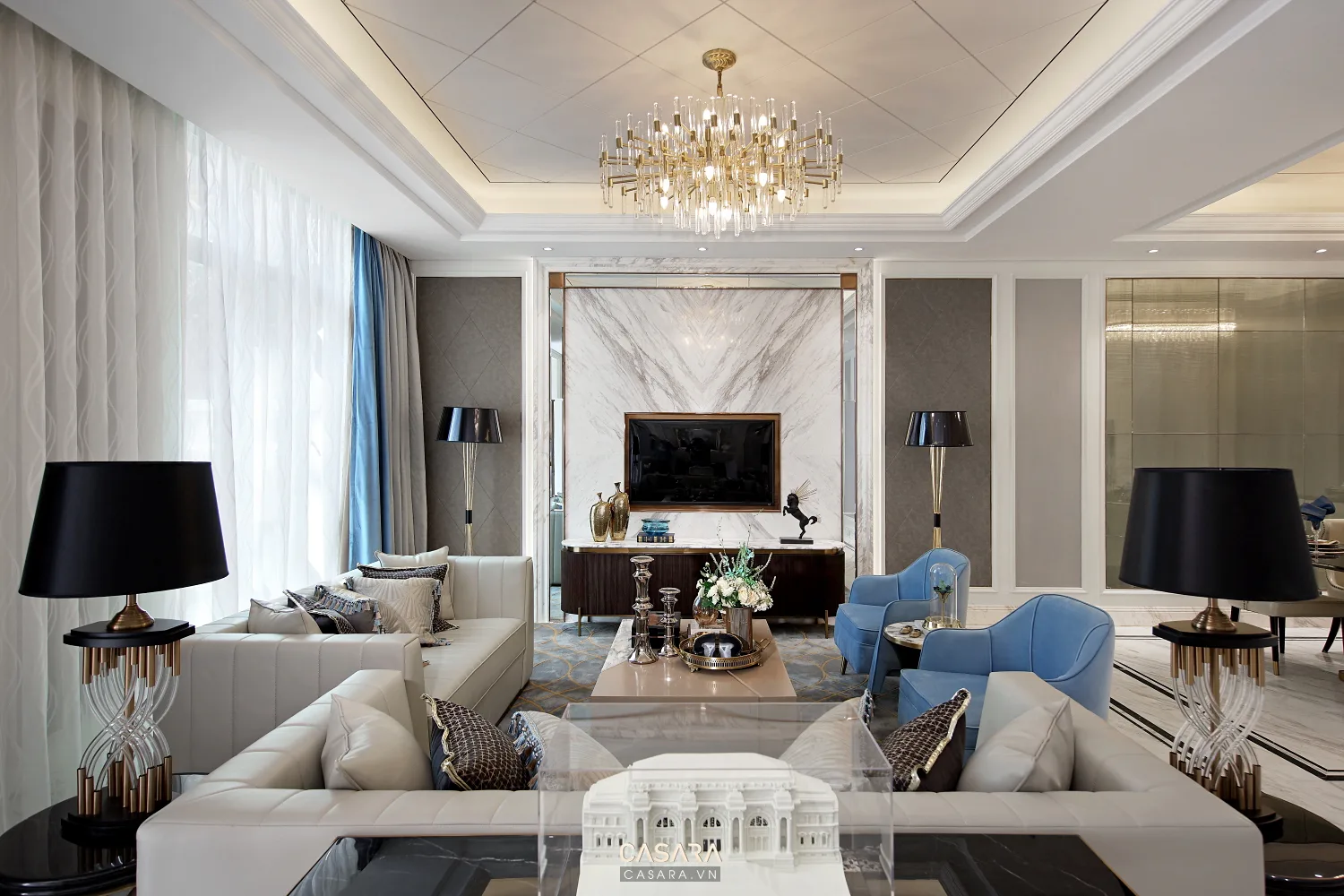 Phòng khách luxury có sofa sáng, đèn chùm và mảng tivi ốp đá sang trọng