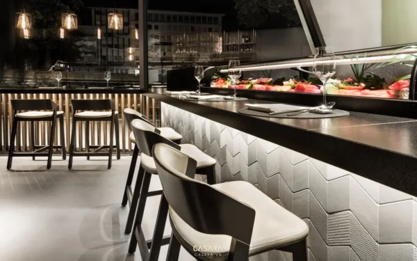 Quầy bar sushi sang trọng với ánh sáng ấm áp và thiết kế hiện đại.