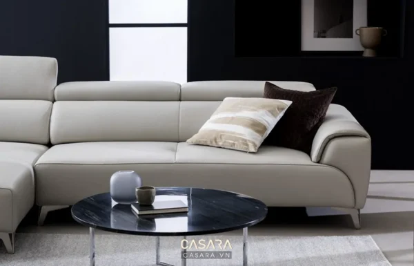 Phòng khách hiện đại với sofa da sáng màu và bàn tròn đen.
