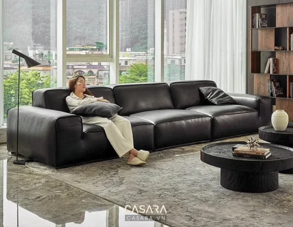 Phòng khách sang trọng với bộ sofa da đen hiện đại và ánh sáng tự nhiên.