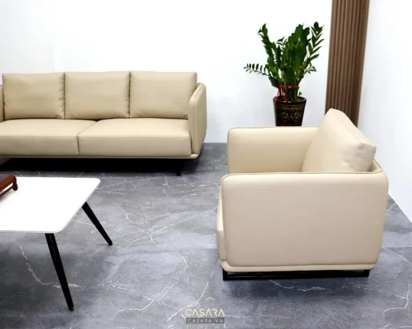 Phòng khách hiện đại với sofa da màu be và cây xanh trang trí.