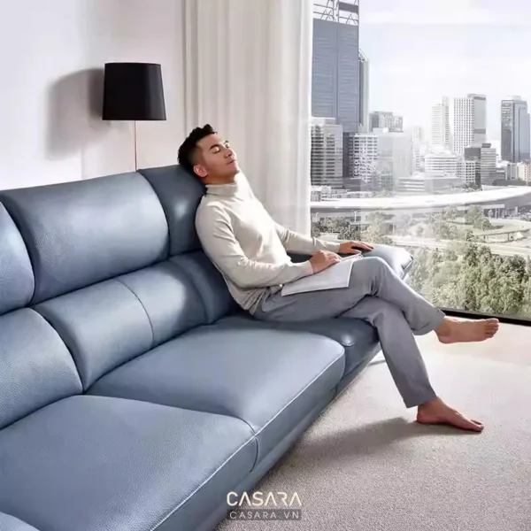 Người đàn ông thư giãn trên chiếc sofa màu xanh dương hiện đại.