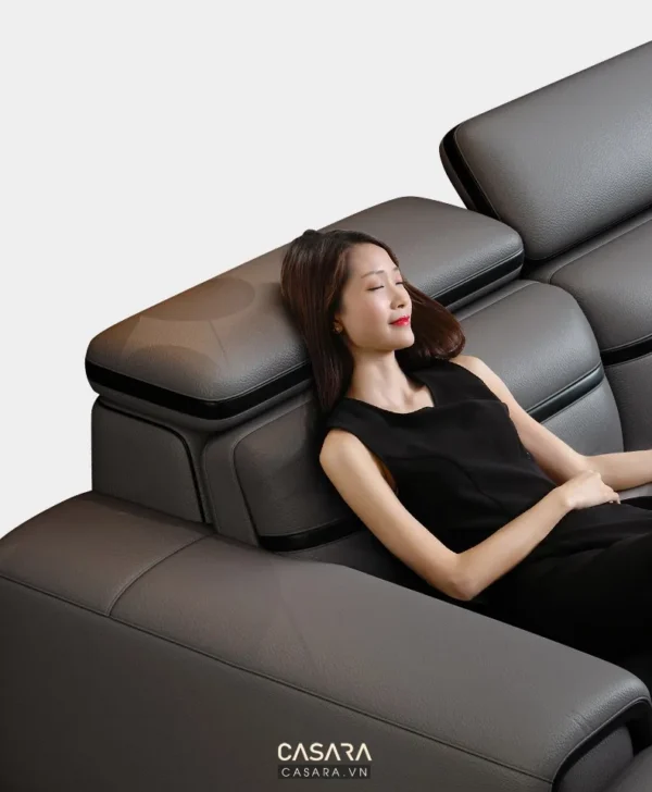 Người phụ nữ thư giãn trên ghế sofa da cao cấp màu xám.