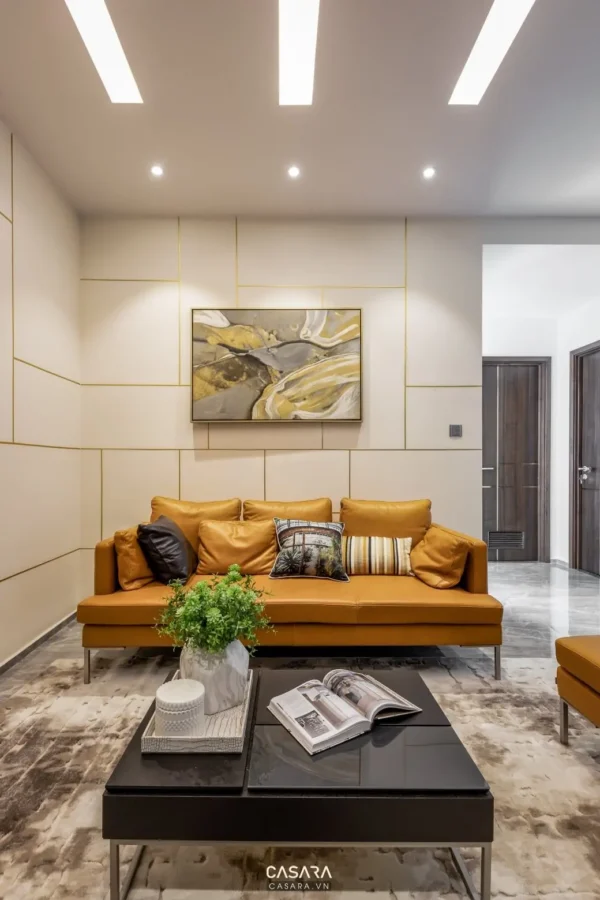Phòng khách hiện đại với sofa da cam nổi bật, tranh trừu tượng tinh tế.