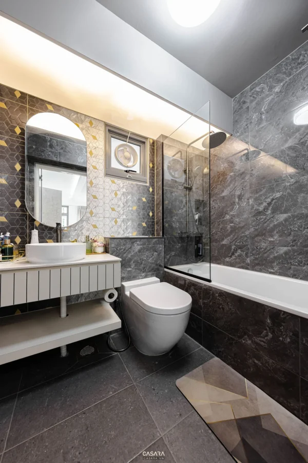Phòng tắm hiện đại, sang trọng với gạch ốp họa tiết và gương lớn.