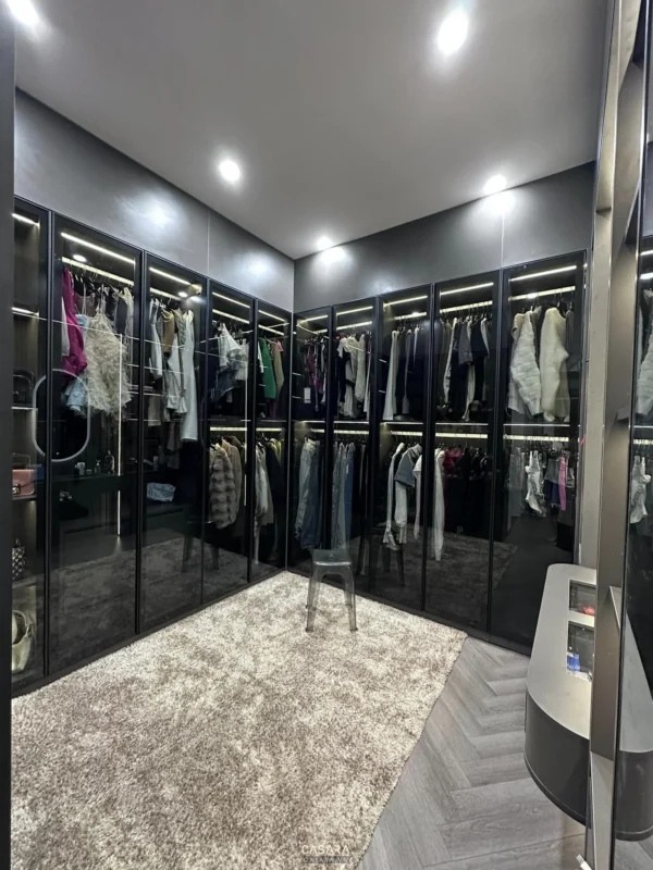 Phòng thay đồ sang trọng với tủ kính đen và thảm trắng mềm mại.