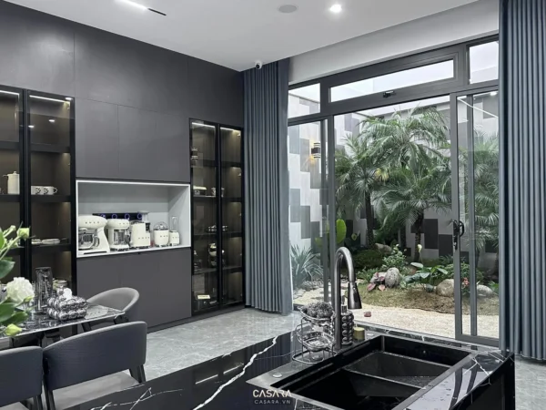 Phòng bếp hiện đại, sang trọng với tông màu xám chủ đạo và view vườn.