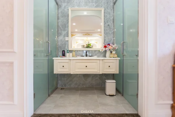 Phòng tắm sang trọng với nội thất trắng tinh tế, ánh sáng dịu nhẹ.