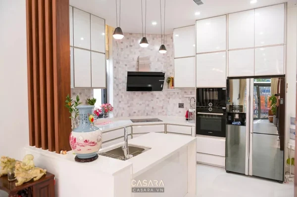 Phòng bếp hiện đại, sang trọng với tông trắng chủ đạo và điểm nhấn gỗ.