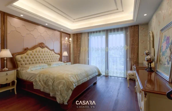 Phòng ngủ sang trọng với giường lớn, nội thất gỗ và cửa sổ view đẹp.