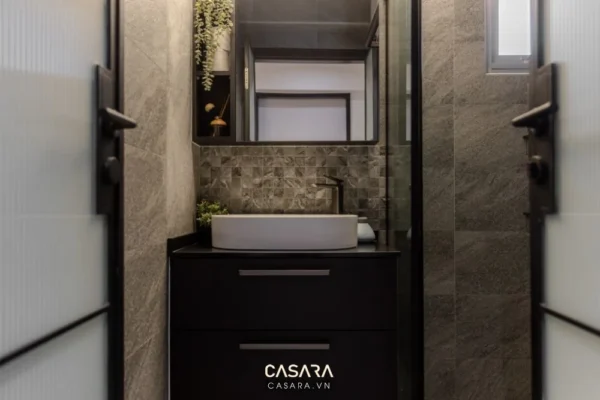 Phòng tắm hiện đại, tối giản với gạch đá xám và nội thất đen.