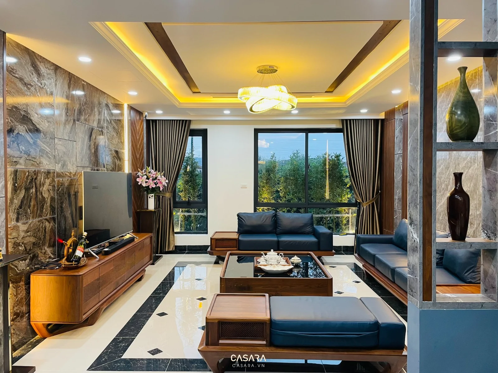 Vách tivi gỗ đá trong phòng khách rộng với sofa chữ L