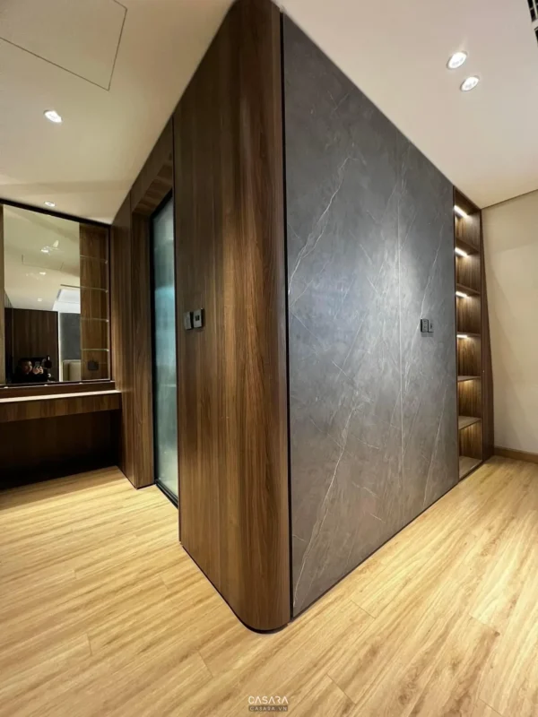 Góc phòng với tủ âm tường gỗ vân đá hiện đại, sang trọng.