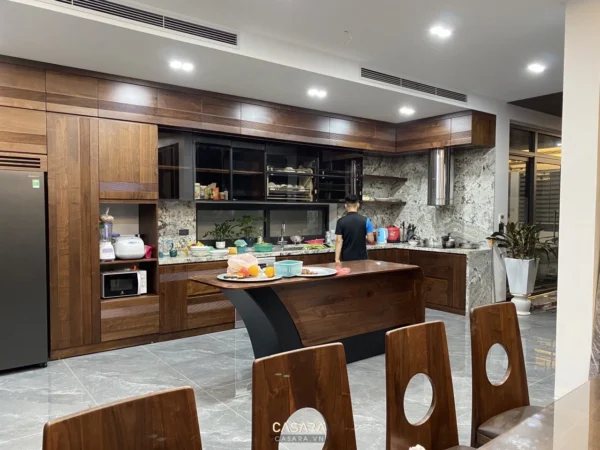 Phòng bếp hiện đại, rộng rãi với nội thất gỗ và đá sang trọng.