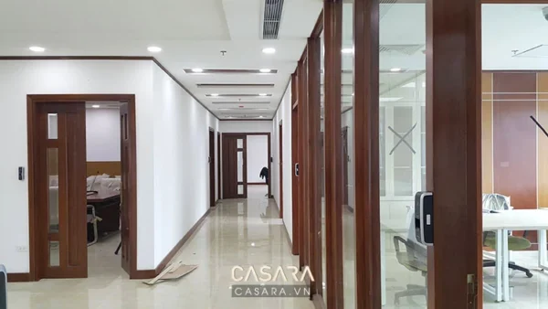 Hành lang văn phòng hiện đại với cửa gỗ và sàn bóng loáng.
