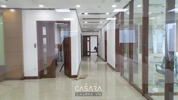 Hành lang văn phòng hiện đại với cửa kính và sàn đá bóng loáng.