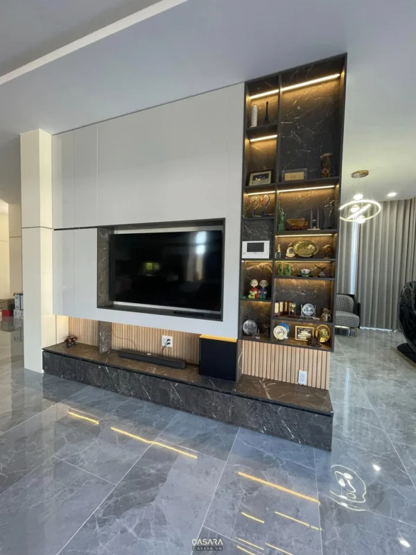 Phòng khách hiện đại với TV lớn và kệ trang trí sang trọng.