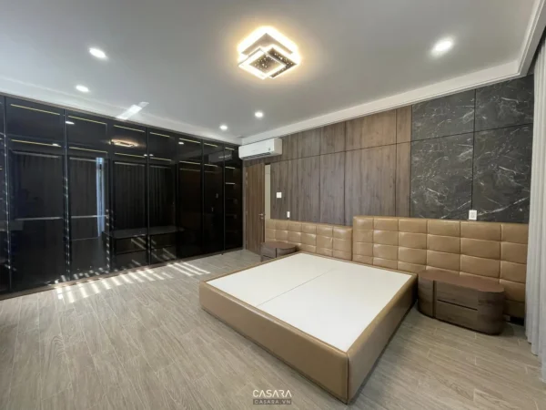 Phòng ngủ hiện đại, sang trọng với tủ âm tường và giường lớn.