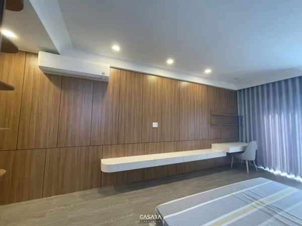 Phòng ngủ hiện đại, sang trọng với nội thất gỗ và ánh sáng ấm áp.